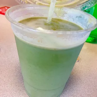 a green smoothie in a plastic cup