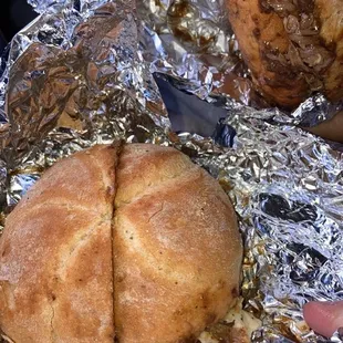 a person holding a sandwich wrapped in foil