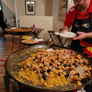 a man serving a large pan of food