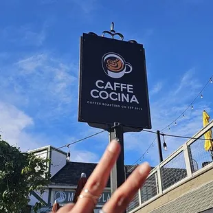 a hand in front of a sign