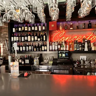 a bar with wine glasses hanging from the ceiling