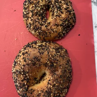 two bagels on a red cutting board
