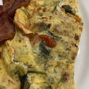 an omelet and bacon on a plate