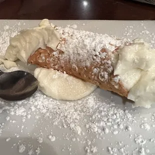 a pastry with powdered sugar and a spoon