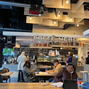 people sitting at tables in a coffee shop