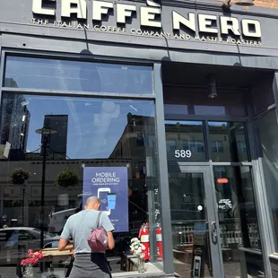 a man walking past a coffee shop