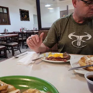 a man sitting at a table with a plate of food