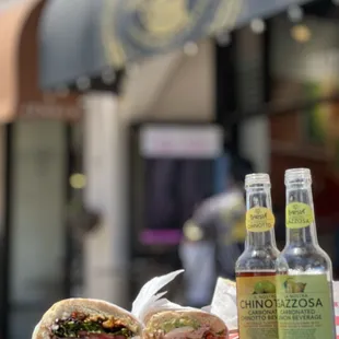 two bottles of beer and a sandwich