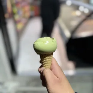 Single scoop green tea gelato in a sugar cone