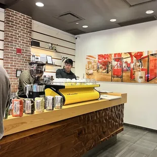 a man standing at a counter in a coffee shop