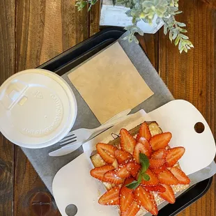 a tray of strawberries and a cup of coffee