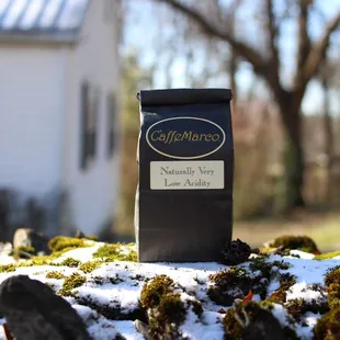 a cup of coffee on a rock in front of a house
