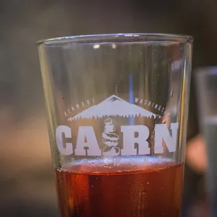 a pint glass with the word cairn on it