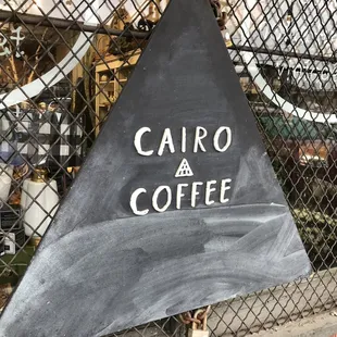 a black triangle with a sign that says cairo coffee