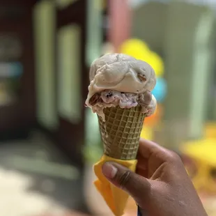 a hand holding an ice cream cone