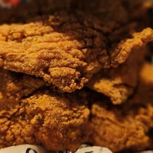 4 Fish  fillets , fries and hushpuppies are underneath the fillets