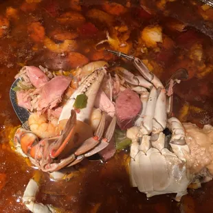a large pot of soup with seafood and vegetables
