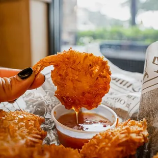 a person dipping a fried chicken nugg