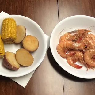 two plates of shrimp and potatoes