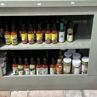 a shelf full of chili sauces