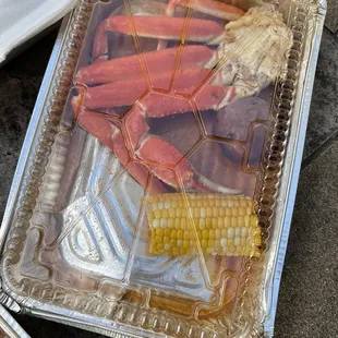 a tray of crab legs and corn on the cob