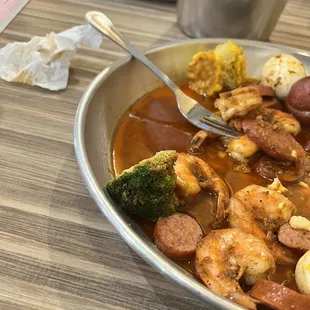a plate of shrimp, sausage, and broccoli