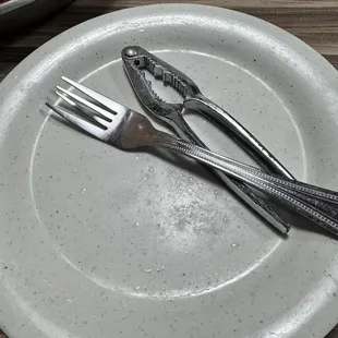 A fork and a crab cracker along with a bib and gloves to dig into everything.