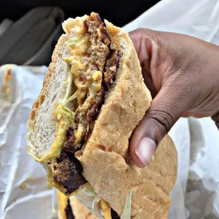 a hand holding a sandwich