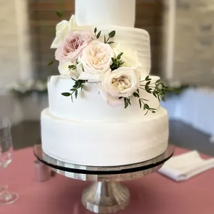 a white wedding cake with fresh flowers