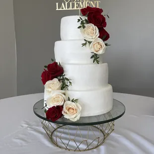 a white wedding cake with red roses