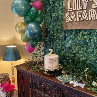 a table with a cake and balloons
