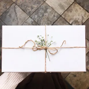 a person holding a gift wrapped in twine