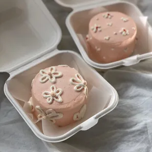 a pink frosted cake in a container