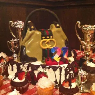Gucci purse cake!  On display with a variety of delicious cupcakes: guava, lilikoi, red velvet. .mmmm