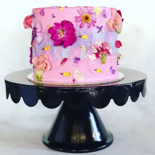 a pink cake with flowers on top