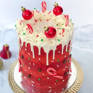 a red cake with white icing and candy canes