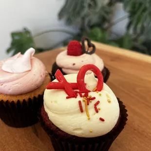 three cupcakes on a wooden board