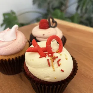 three cupcakes on a wooden table