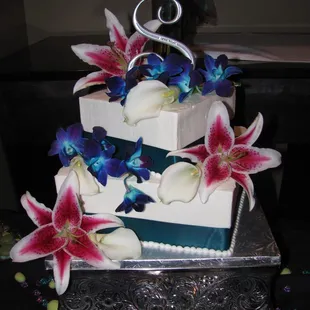 2 tier square buttercream wedding cake decorated with silk flowers