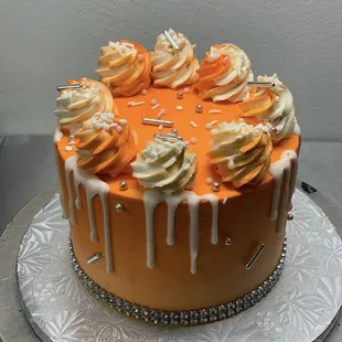 an orange cake with icing and sprinkles