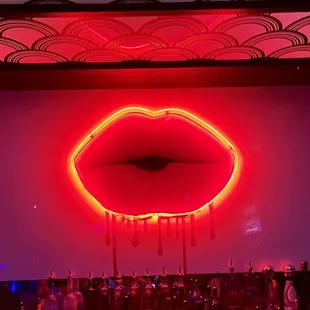 a neon red lips on a wall