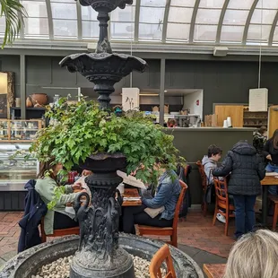 a fountain in a restaurant with people sitting at tables