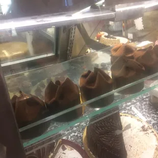 a variety of cakes in a display case