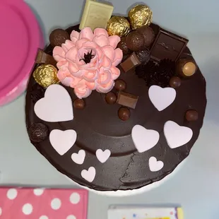 a chocolate cake decorated with pink and white flowers