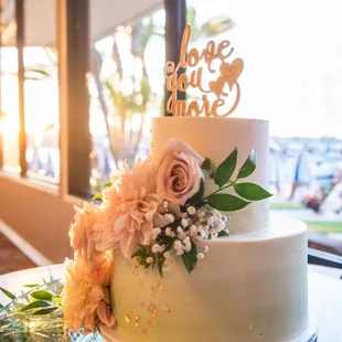 a white wedding cake with flowers on top