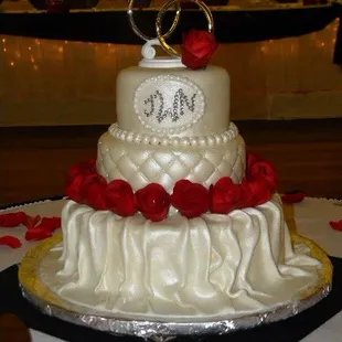 a white wedding cake with red roses