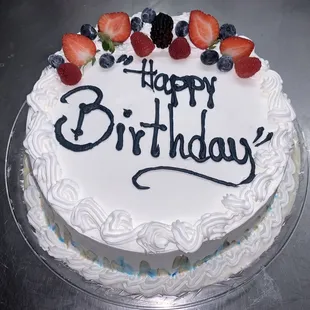 a birthday cake with strawberries and blueberries