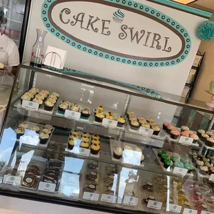 a woman behind the counter of a bakery