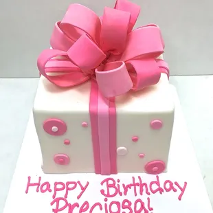 Pink birthday cake with fondant bow.