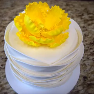 Simple white cake with rippled fondant and a pop of yellow.